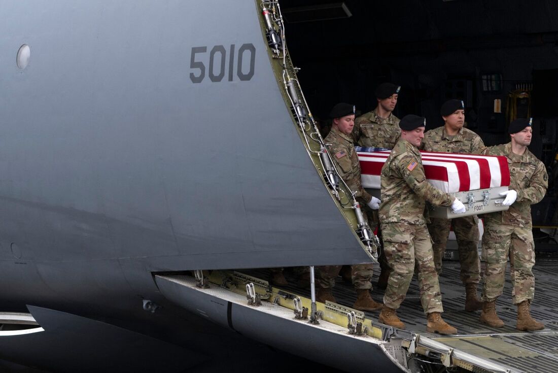 Equipe de transporte do Exército dos EUA move a caixa de transferência contendo os restos mortais do sargento do Exército dos EUA