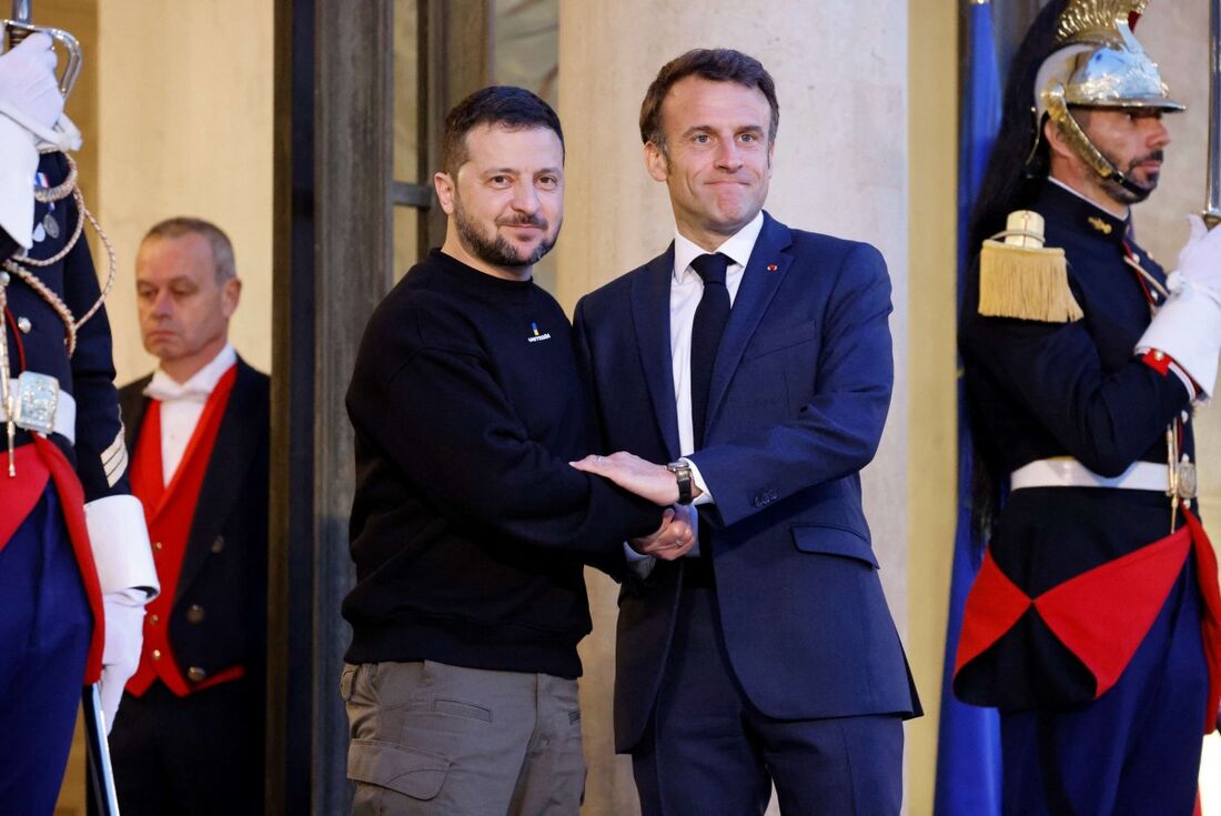 O presidente da Ucrânia, Volodymyr Zelensky (L), é recebido pelo presidente da França, Emmanuel Macron (c), em sua chegada ao palácio presidencial do Eliseu, em Paris