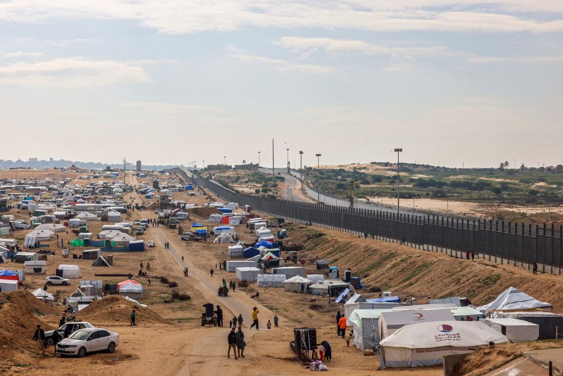 Palestinos deslocados acampam perto da cerca da fronteira entre Gaza e Egito