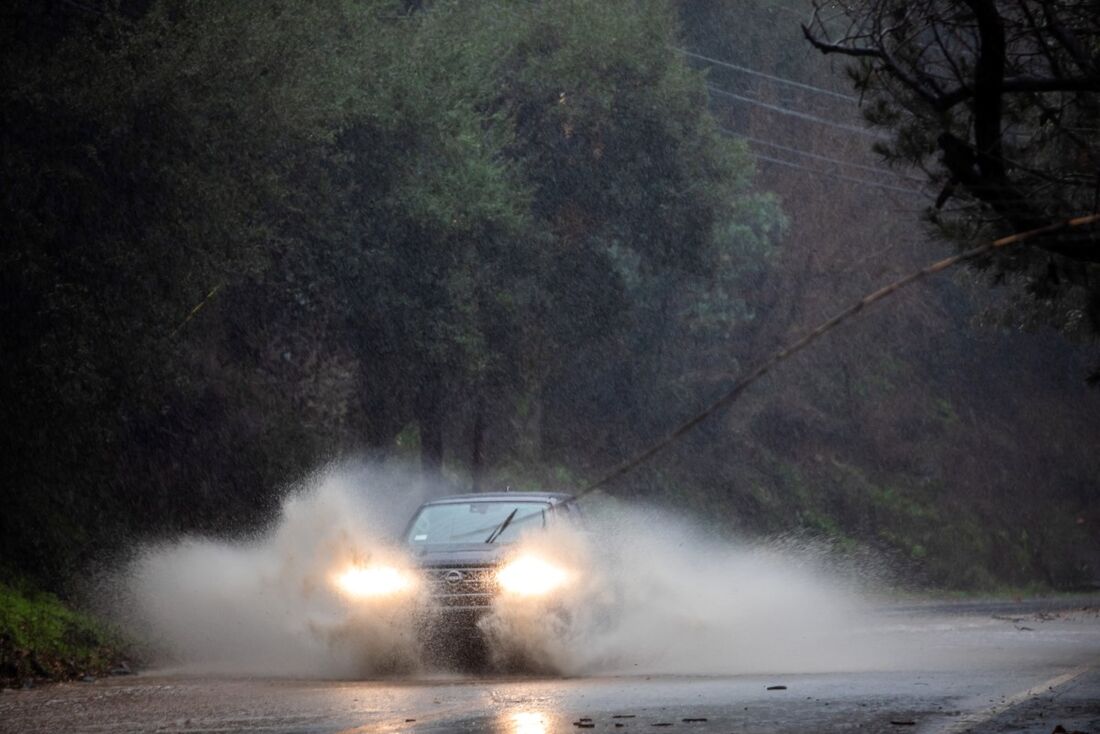 Um carro passa por uma estrada inundada em Topanga, Califórnia