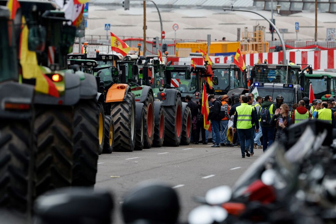 Tratores são apreendidos enquanto manifestantes se reúnem durante um protesto de agricultores em frente ao Ministério da Agricultura, em Madrid, em 21 de fevereiro de 2024