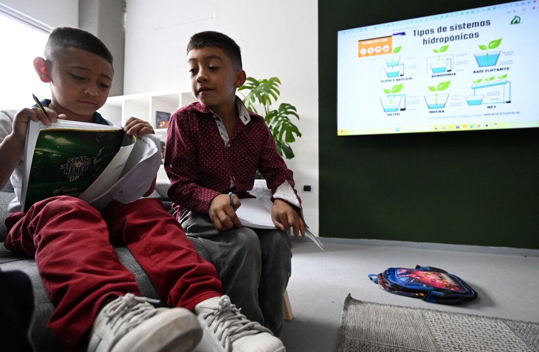 Alejandro Suarez (E) e seu primo Bryan assistem às aulas na Escola Internacional Still I Rise, na Ciudad Bolívar, ao sul de Bogotá