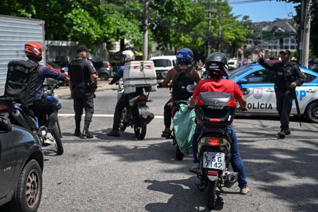 Membros da Polícia Militar do Estado do Rio de Janeiro vigiam a entrada da favela do Complexo do Alemão