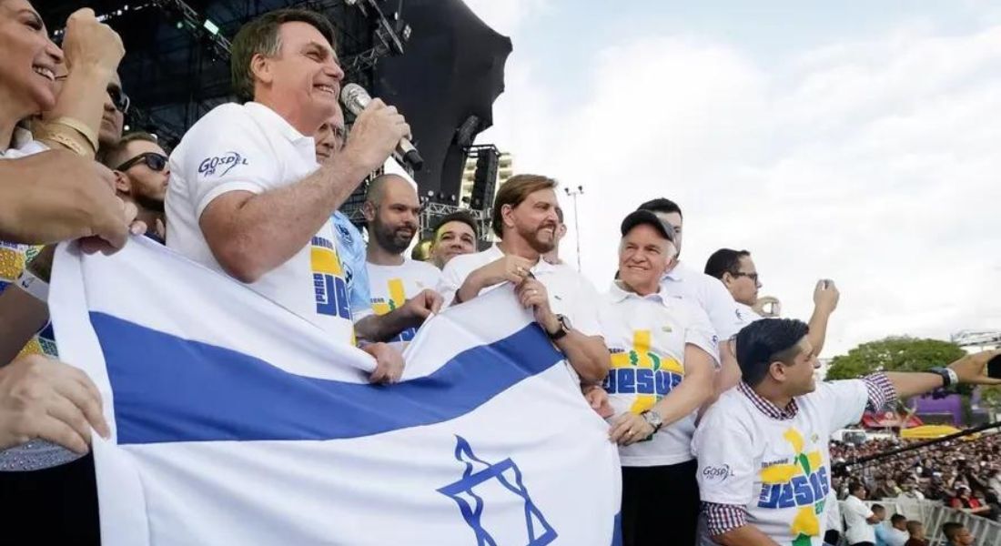 Jair Bolsonaro em evento com a bandeira de Israel em mãos, em 2019