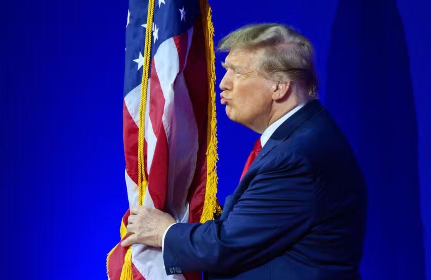 Trump beija a bandeira dos EUA durante reunião anual da Conferência de Ação Política Conservadora em National Harbor, Maryland 