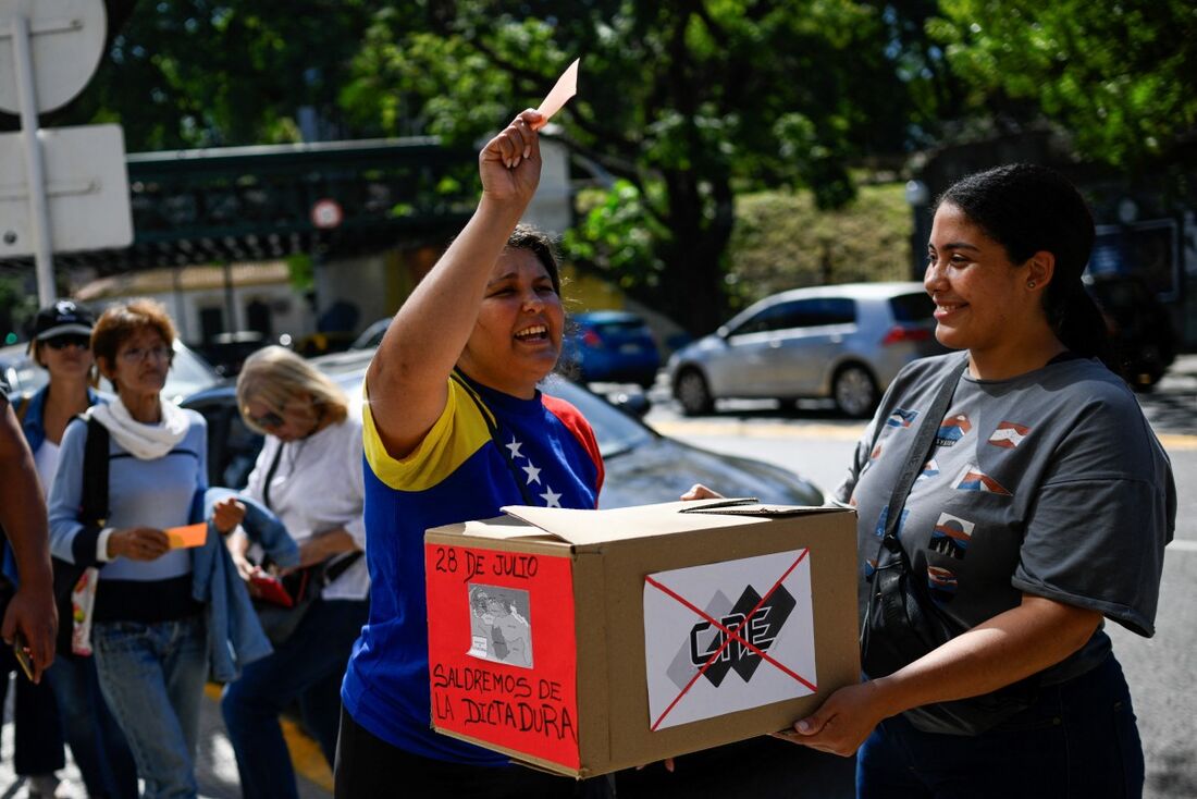 Venezuelanos na Argentina simulam uma votação durante um protesto em frente à embaixada da Venezuela em Buenos Aires em 25 de março de 2024