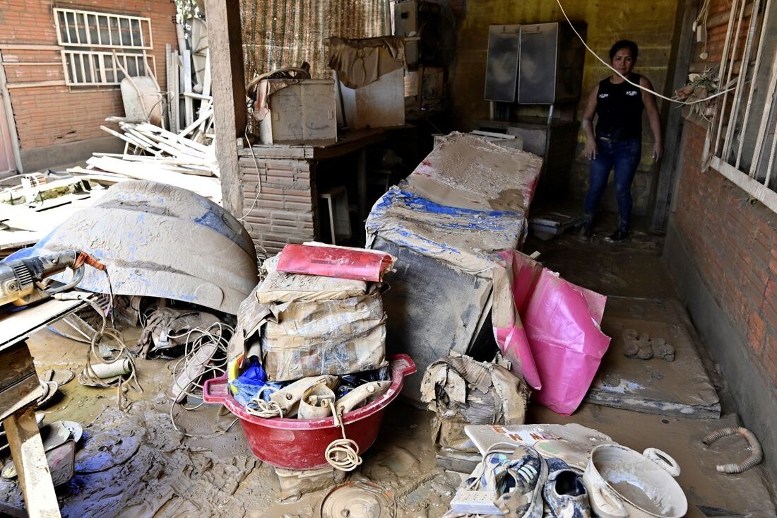 Damaris Hidalgo tenta recuperar alguns pertences depois que o transbordamento do rio Acre inundou sua casa em Cobija 