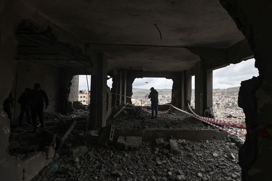 Palestinos inspecionam os destroços da casa de Moaz al-Masry