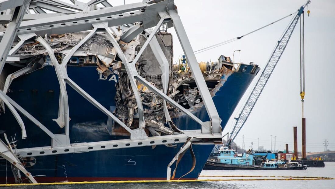 Foto da Guarda Costeira dos EUA mostra uma parte da ponte apoiada sobre um navio porta-contêiners Dali