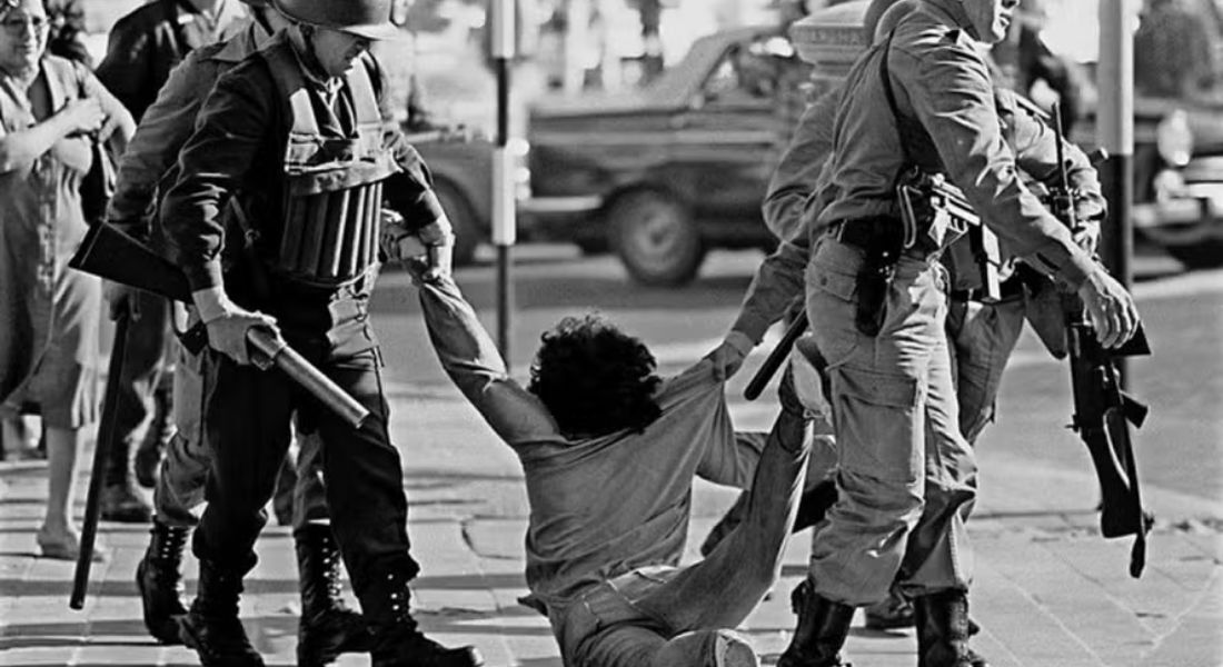 Guardas da polícia federal detêm homem durante marcha contra a ditadura em Buenos Aires em março de 1982