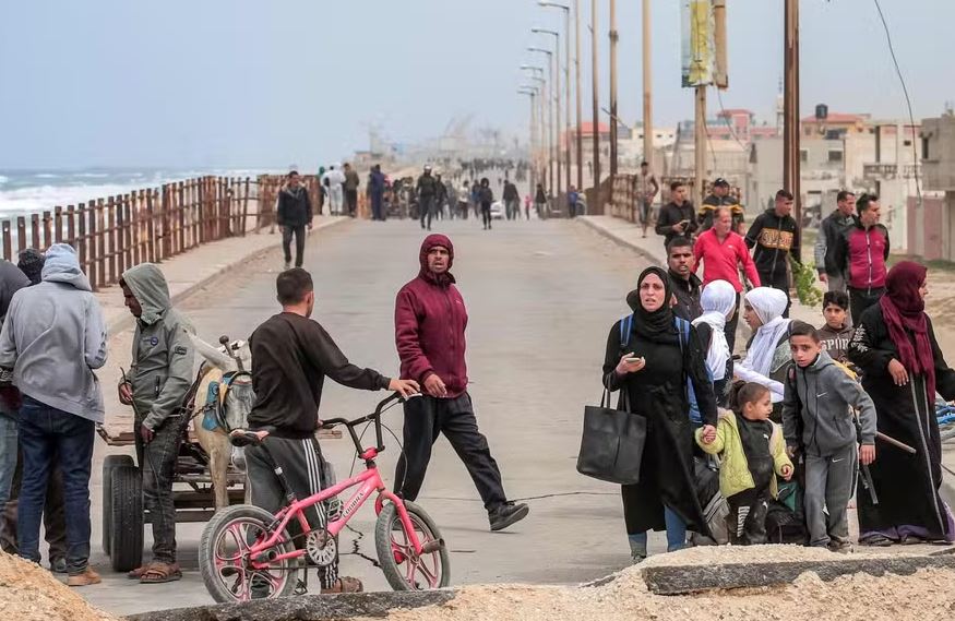 Palestinos deslocados fugindo da área próxima ao hospital al-Shifa chegam pela rodovia costeira ao campo de refugiados de Nuseirat, no centro da Faixa de Gaza