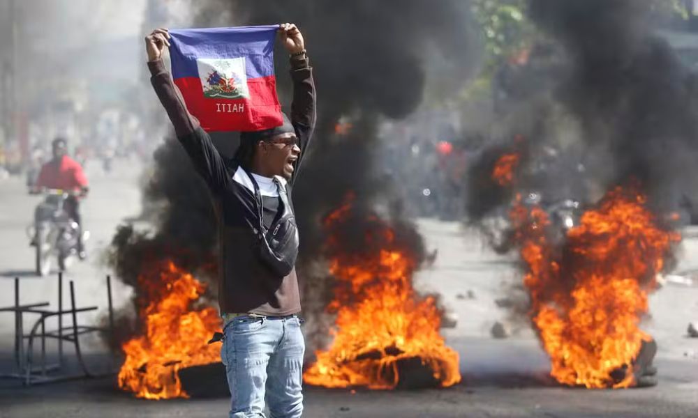 Manifestante com a baideira do Haiti em 1&ordm; de março de 2024