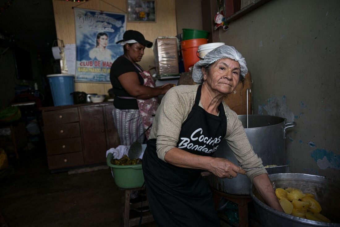Um grupo de mulheres encarregadas de um refeitório prepara alimentos com cascas, folhas e caules de vegetais e frutas usando técnicas culinárias para otimizar a alimentação em Villa el Salvador, periferia sul de Lima