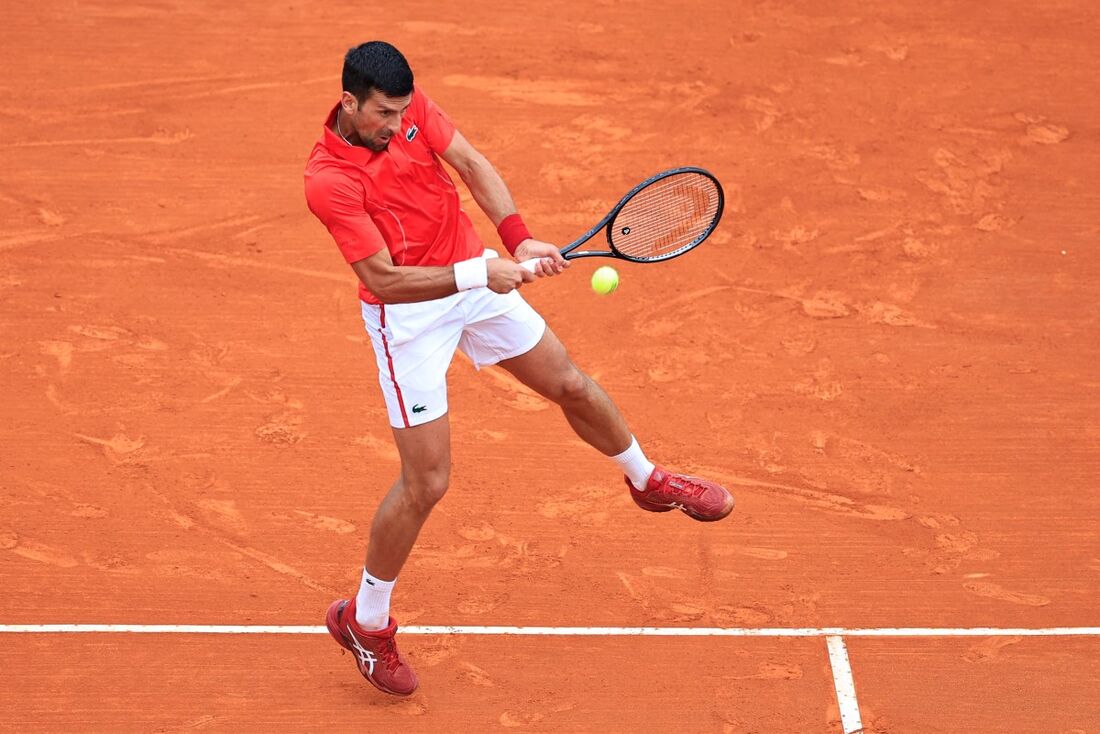 O sérvio Novak Djokovic devolve o backhand ao russo Roman Safiullin durante a partida de tênis das oitavas de final do Monte Carlo 