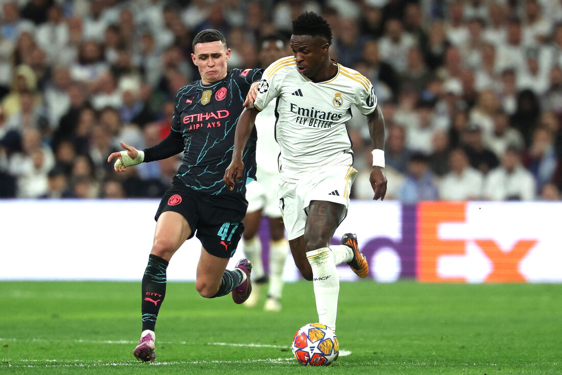 Vinicius Júnior e Phil Foden disputam bola no jogo de ida