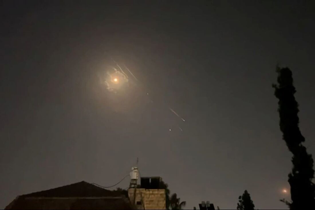 Explosões iluminam o céu de Jerusalém durante o ataque iraniano a Israel.