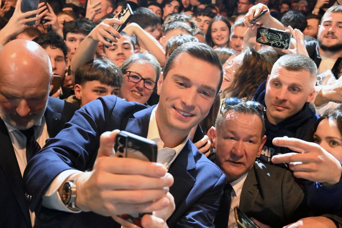 O presidente do partido de extrema-direita francês Rassemblement National (RN) e principal candidato eleitoral do partido para o Parlamento Europeu, Jordan Bardella (C), posa para uma selfie com apoiadores