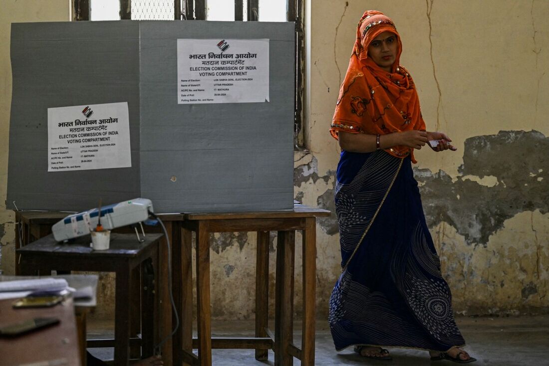 Uma mulher caminha após votar em uma seção eleitoral durante a segunda fase de votação das eleições gerais da Índia 