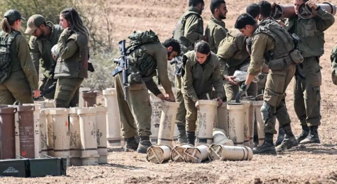 Soldados do exército israelense manuseiam projéteis de artilharia em uma posição perto da Faixa de Gaza, no sul de Israel  Foto: YURI CORTEZ/AFP