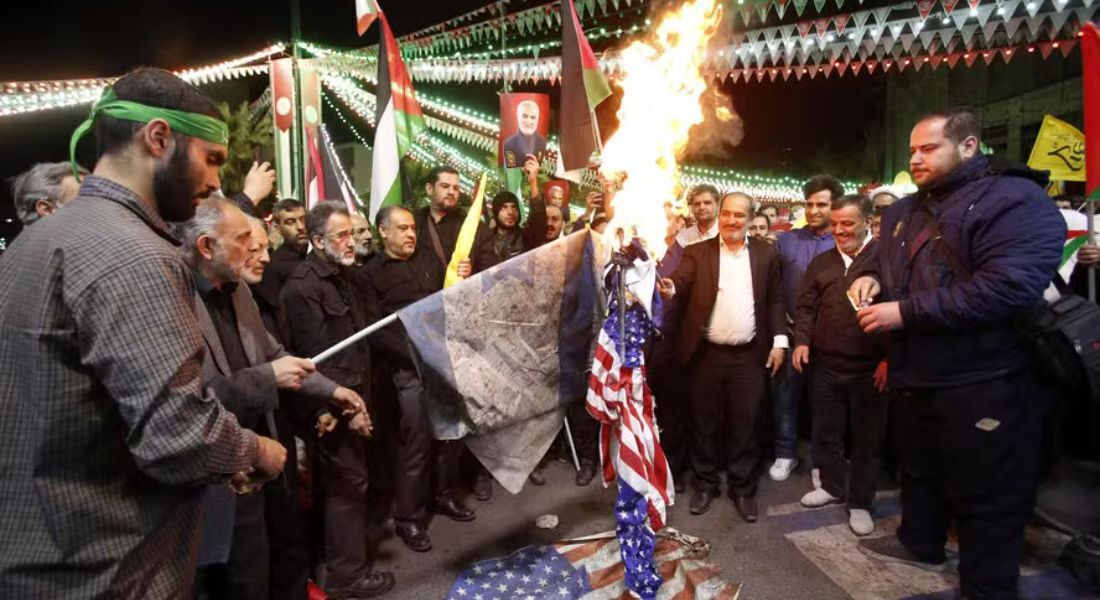 Manifestantes queimam bandeiras dos EUA em protesto contra ataque israelense à embaixada na Síria