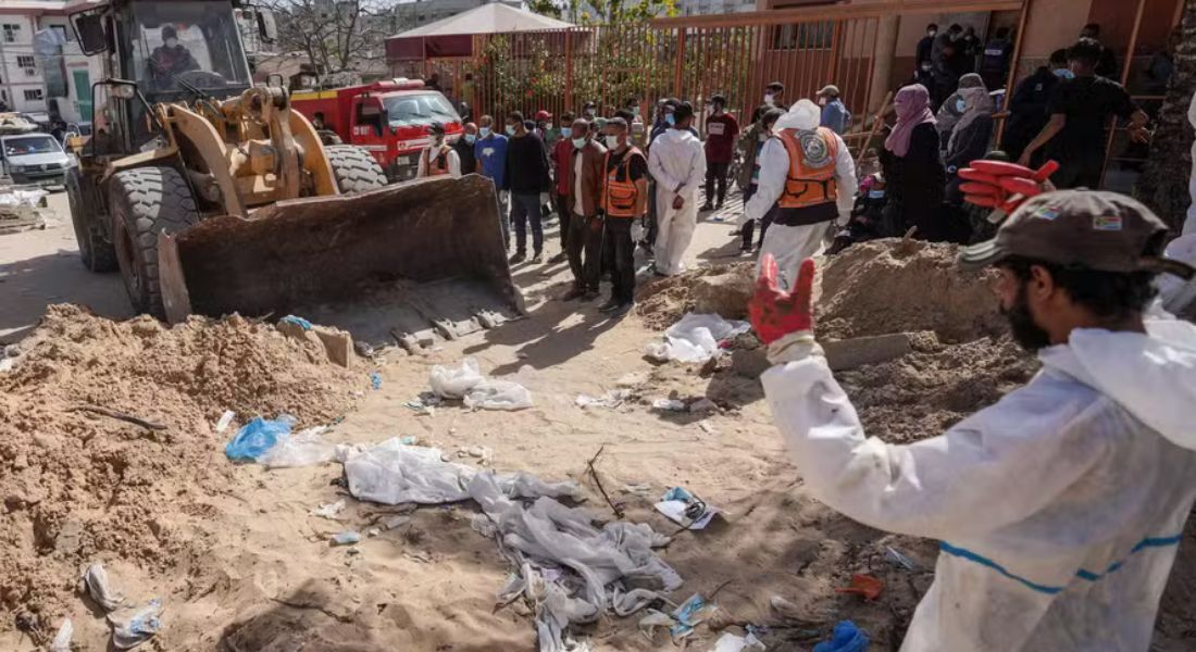 Profissionais de saúde palestinos procuram corpos enterrados no complexo do hospital Nasser em Khan Yunis, no sul da Faixa de Gaza.  Foto: 