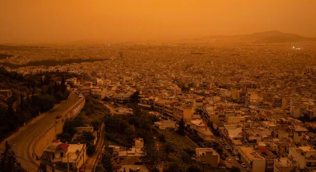 Vista da cidade de Atenas envolta na névoa laranja