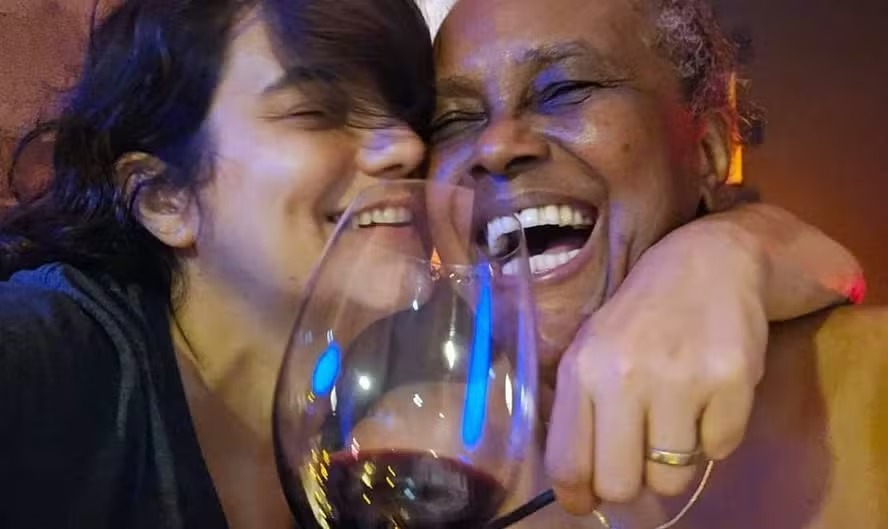 Sandra Sá e a esposa Simone Malafaia em raro momento íntimo, com sorrisos e vinho