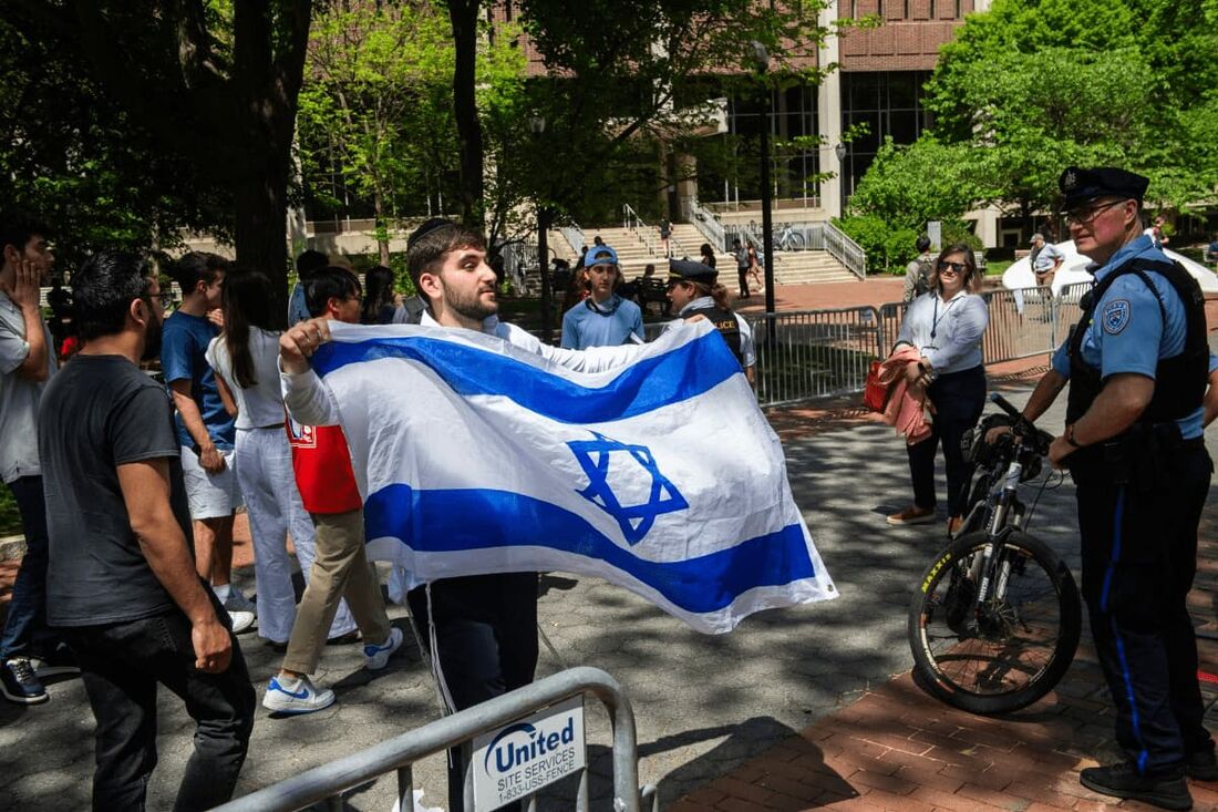 Um estudante agita uma bandeira israelense enquanto estudantes pró-palestinos fazem uma manifestação no campus da Universidade Estadual de Portland em Portland, Oregon.