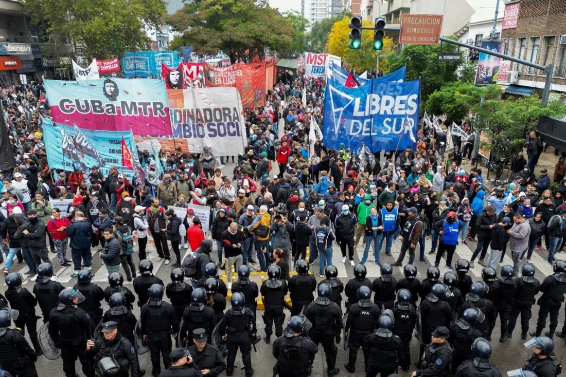 Vista aérea mostrando membros de movimentos sociais sendo bloqueados pelas forças de segurança a caminho da Residência Presidencial de Olivos para protestar contra as reformas e cortes propostos pelo presidente Javier Milei.