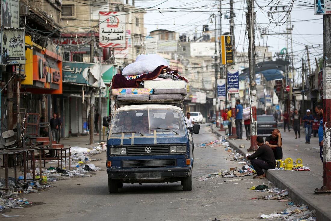 Palestinos transportam seus pertences na traseira de uma van enquanto fogem de Rafah, no sul da Faixa de Gaza, para um local mais seguro 