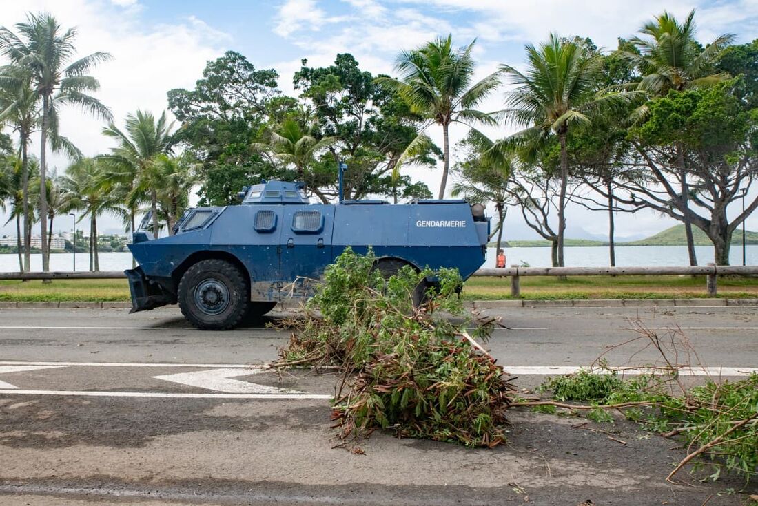 Um veículo blindado da Gendarmerie passa pelo bloqueio de filtragem instalado nas baías