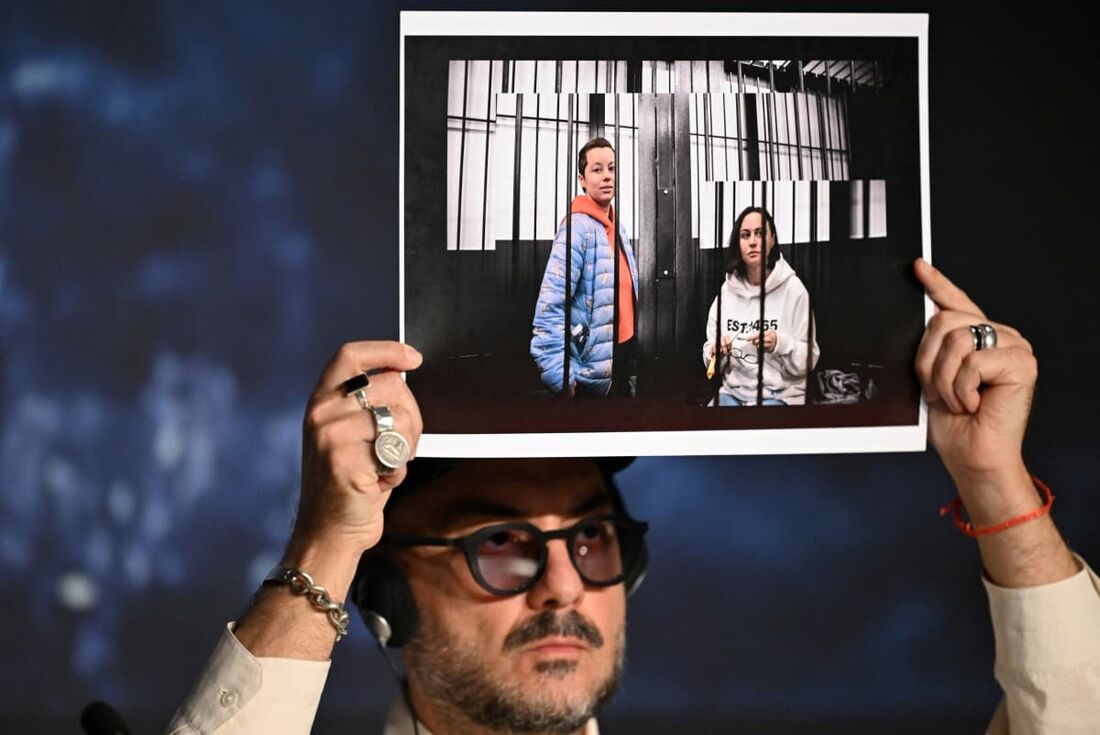 O diretor russo Kirill Serebrennikov segura uma foto da diretora Yevgeniya Berkovich, escritora Svetlana Petriychuk, detida na Rússia durante uma coletiva de imprensa do filme "Limonov: The Ballad"