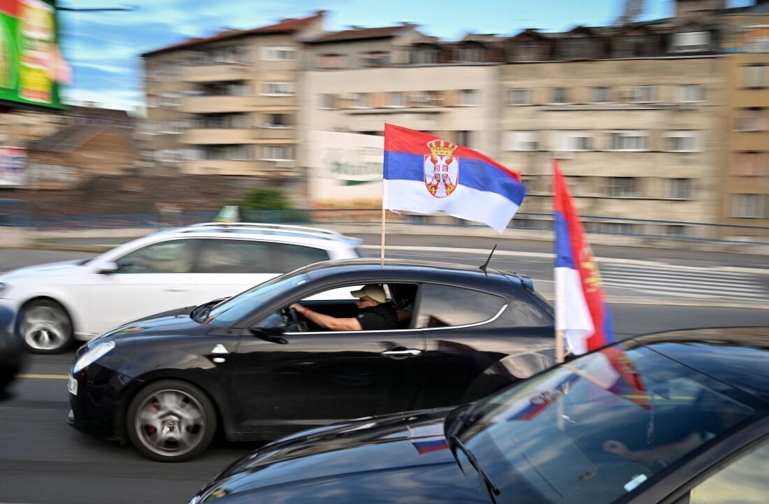 Os carros hasteiam a bandeira nacional sérvia enquanto circulam por Belgrado em protesto contra a votação da ONU para estabelecer um dia anual de memória do genocídio de Srebrenica de 1995