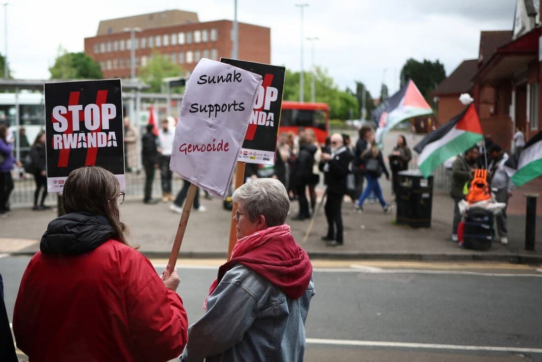 Manifestantes pró-palestinos seguram cartazes enquanto se reúnem do lado de fora durante uma visita do primeiro-ministro britânico e líder do Partido Conservador, Rishi Sunak