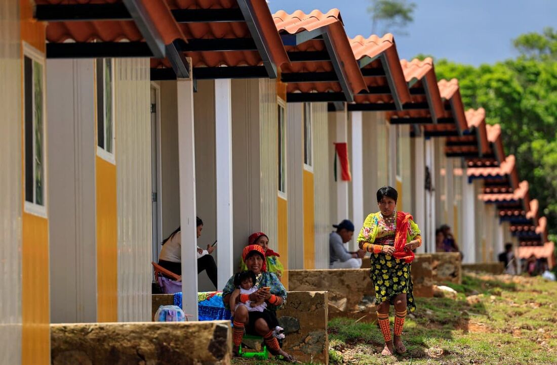 Gunas indígenas sentam-se do lado de fora de suas novas casas em Nuevo Carti, Comarca de Guna Yala, na costa caribenha do Panamá