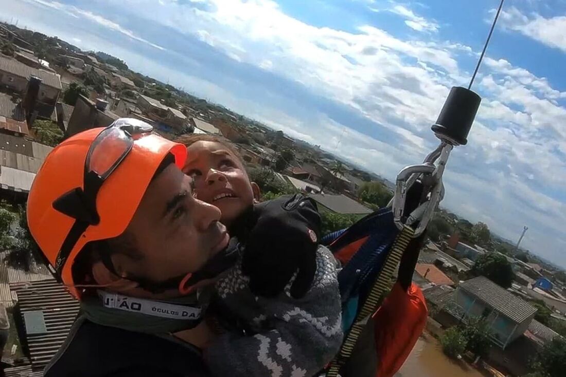 Captura de um vídeo divulgado pela Marinha do Brasil em 6 de maio de 2024 mostra um membro da Marinha do Brasil resgatando uma criança de helicóptero no bairro Mathias Velho, em Canoas, Rio Grande do Sul