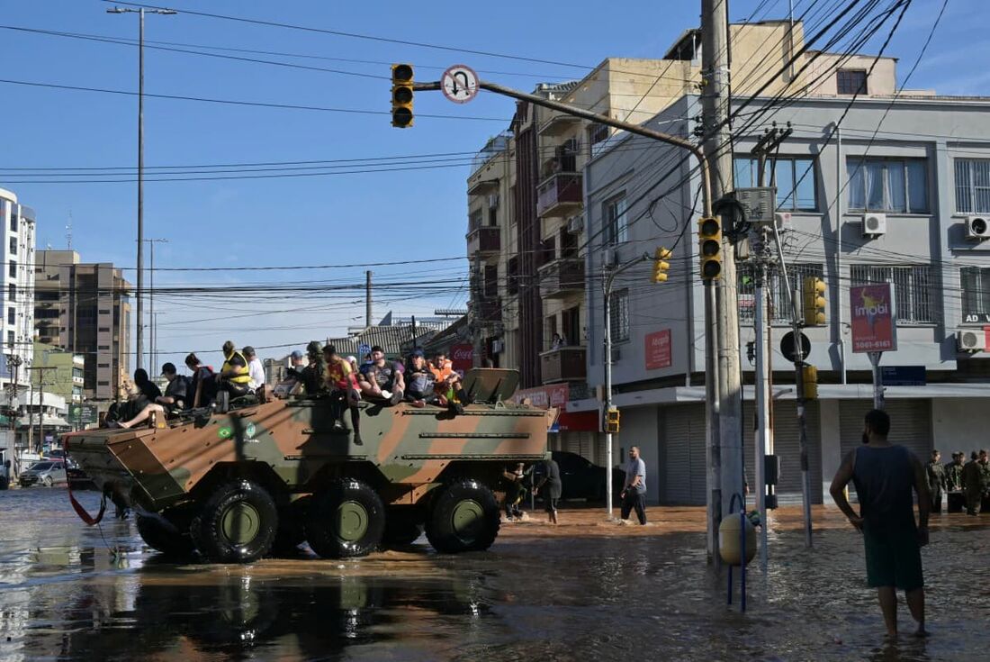 Pessoas são retiradas de uma área inundada em um veículo militar após inundações devido às fortes chuvas em Porto Alegre, estado do Rio Grande do Sul, Brasil, em 6 de maio de 2024.