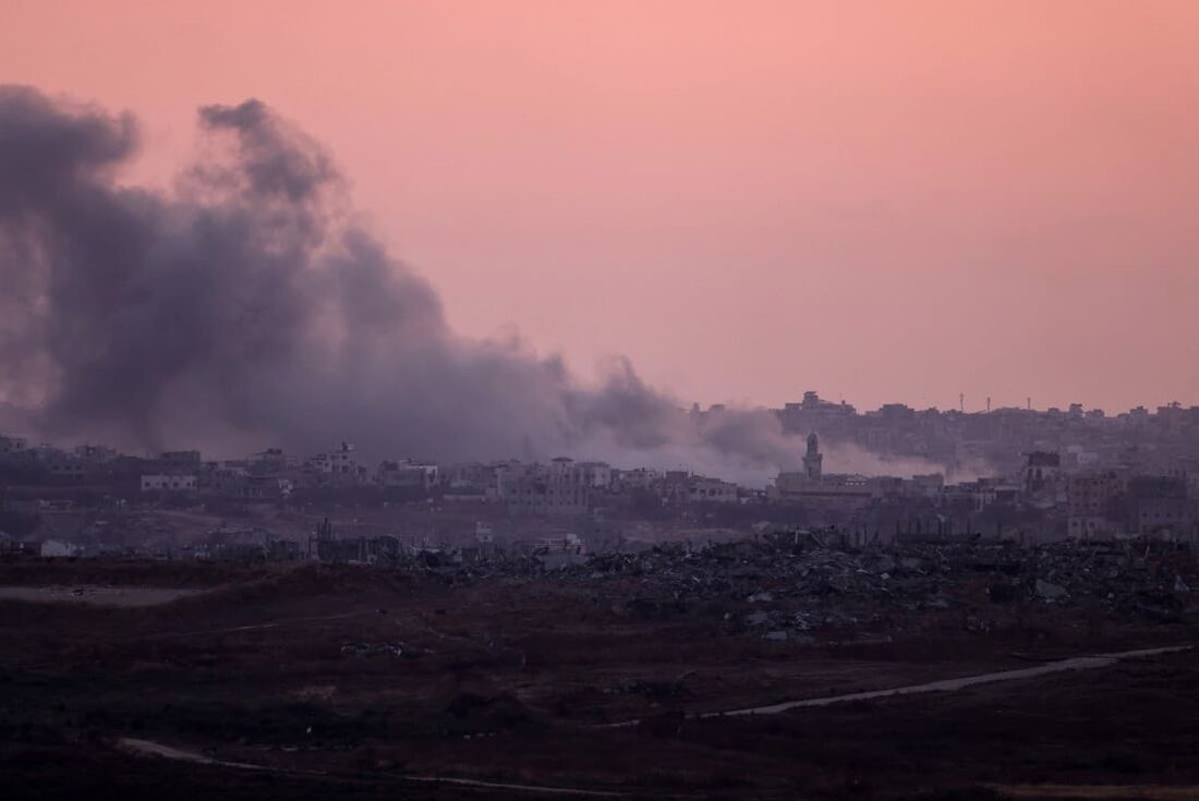 Fumaça subindo sobre o território palestiniano após bombardeamento israelita.