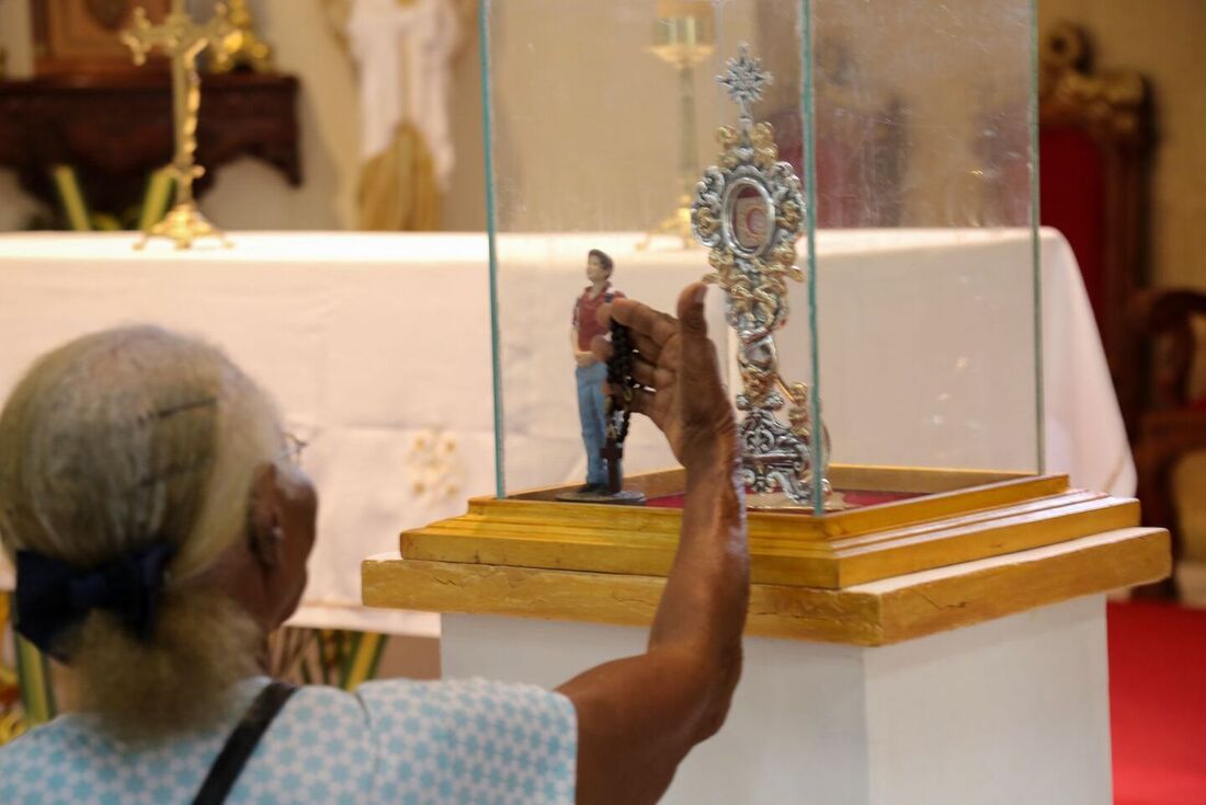 Fiéis oram em frente à relíquia de primeiro grau do beato e futuro santo Carlo Acutis