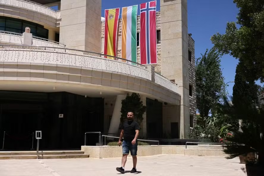 Prédio municipal palestino em Ramallah, na Cisjordânia, com as bandeiras da Espanha, Irlanda e Noruega após os países apoiarem o reconhecimento do Estado palestino. 