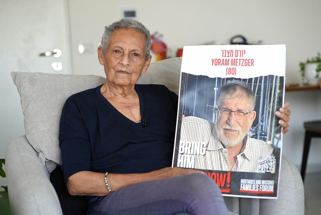 A ex-refém israelense de militantes palestinos do Hamas, Tami Metzger, posa para uma foto com um retrato de seu marido Yoram.