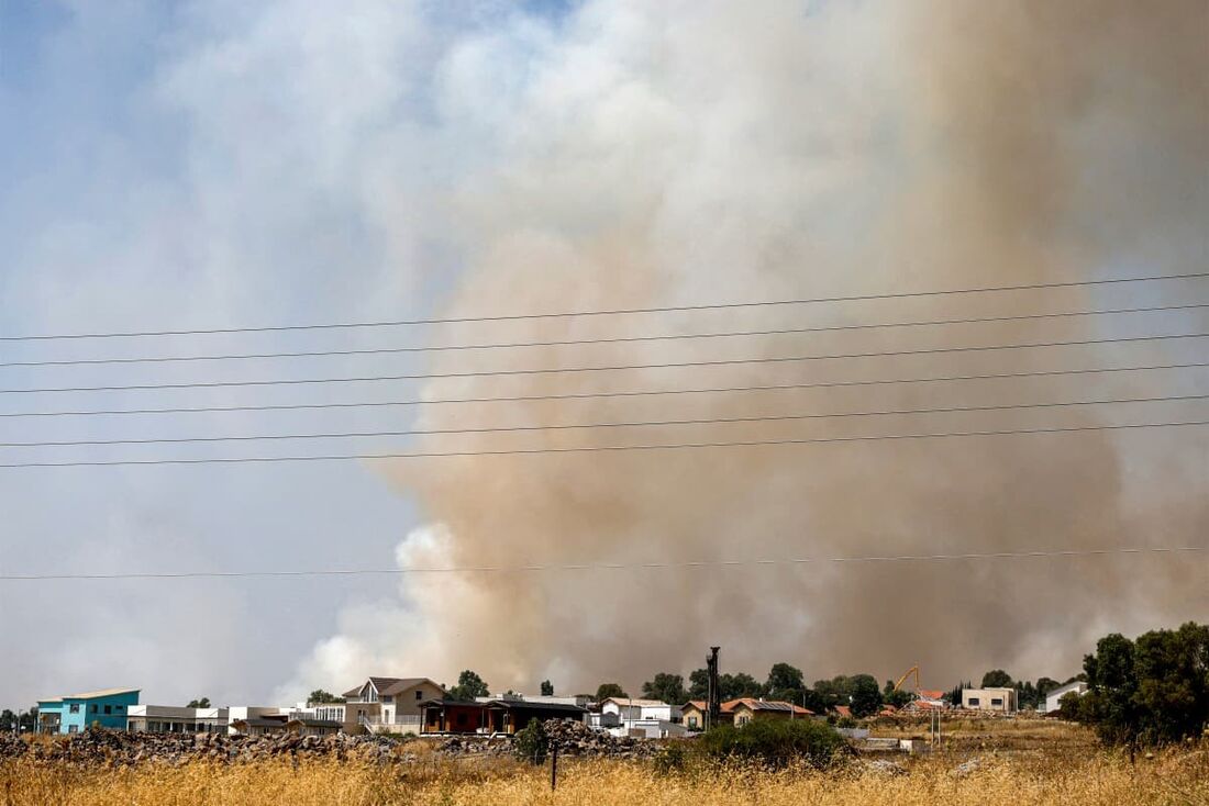 Nuvens de fumaça sobem de um incêndio em um campo depois que foguetes lançados do sul do Líbano pousaram perto de Kela, nas Colinas de Golã, anexadas por Israel