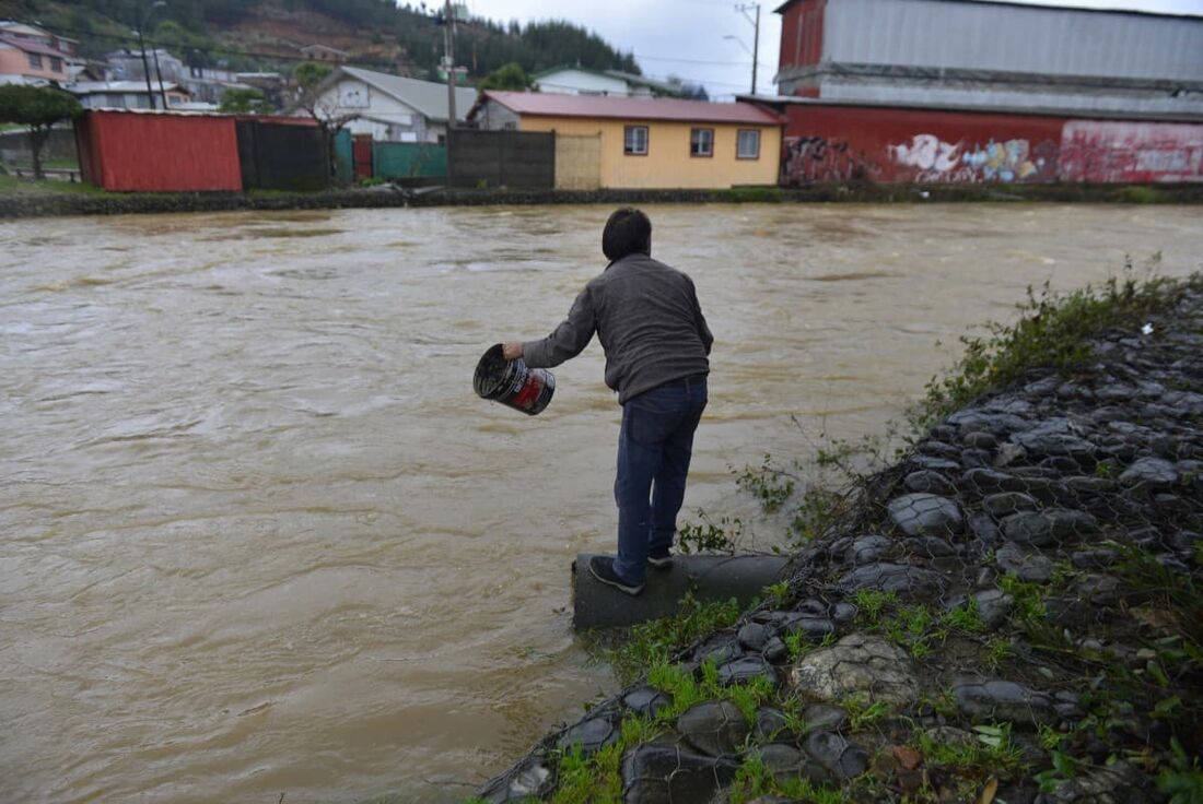 Uma pessoa às margens do rio Curanilahue, região de Biobio, Chile, em 13 de junho de 2024, após fortes chuvas