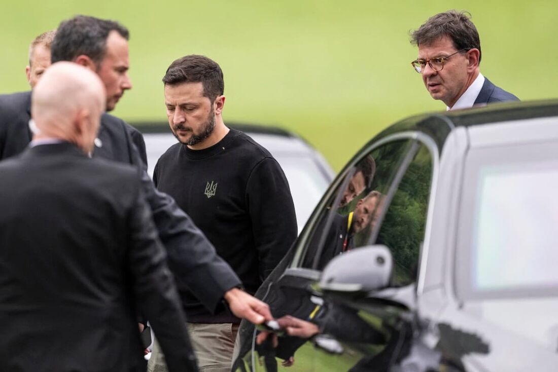 O presidente da Ucrânia, Volodymyr Zelensky (C), e o embaixador da Suíça na Ucrânia, Felix Baumann (direi), caminham em direção a uma limusine após pousarem perto do Buergenstock Resort, onde acontecerá a Cúpula da Paz na Ucrânia