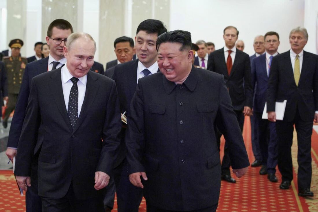 O presidente russo Vladimir Putin (esq) e o líder da Coreia do Norte Kim Jong Un (C) participam de um concerto de gala em Pyongyang