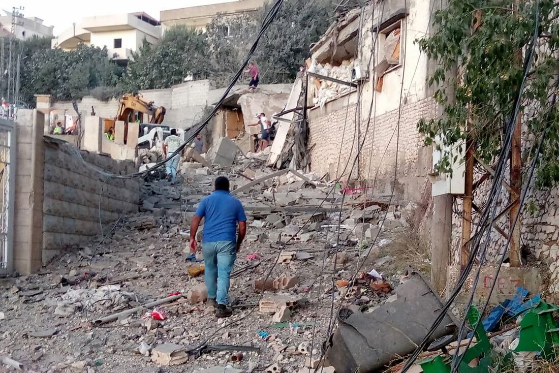 Um libanês passa por casas destruídas após um ataque aéreo israelense na vila de Khiam, no sul do Líbano