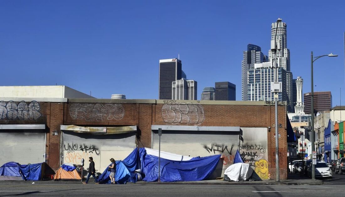 Tendas que abrigam moradores de rua se alinham em frente a vitrines fechadas perto do centro de Los Angeles