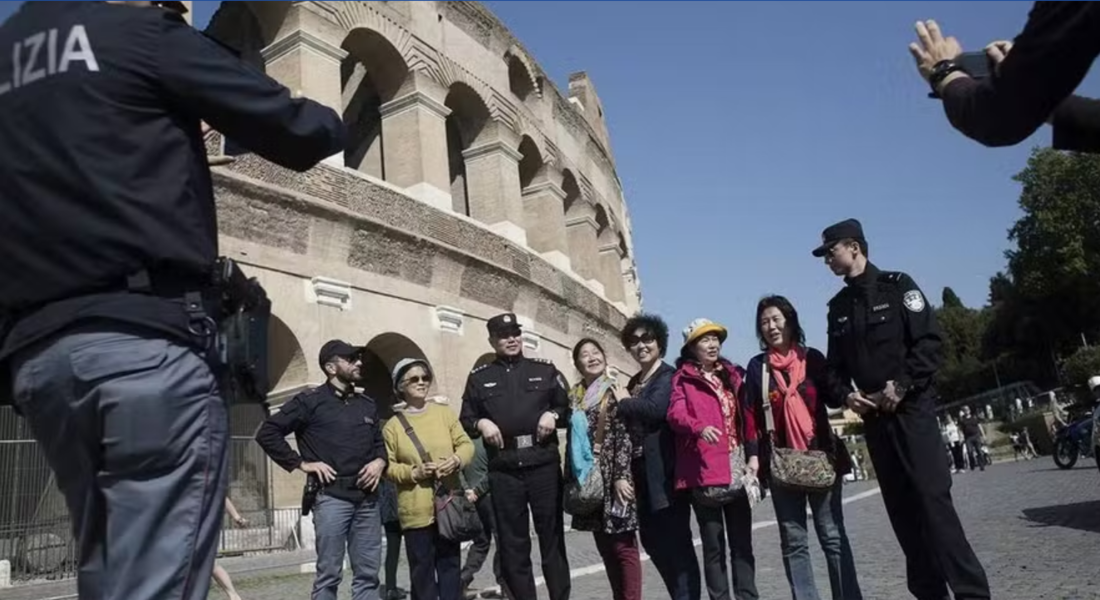 Turistas chineses posam para foto em frente ao Coliseu de Roma 