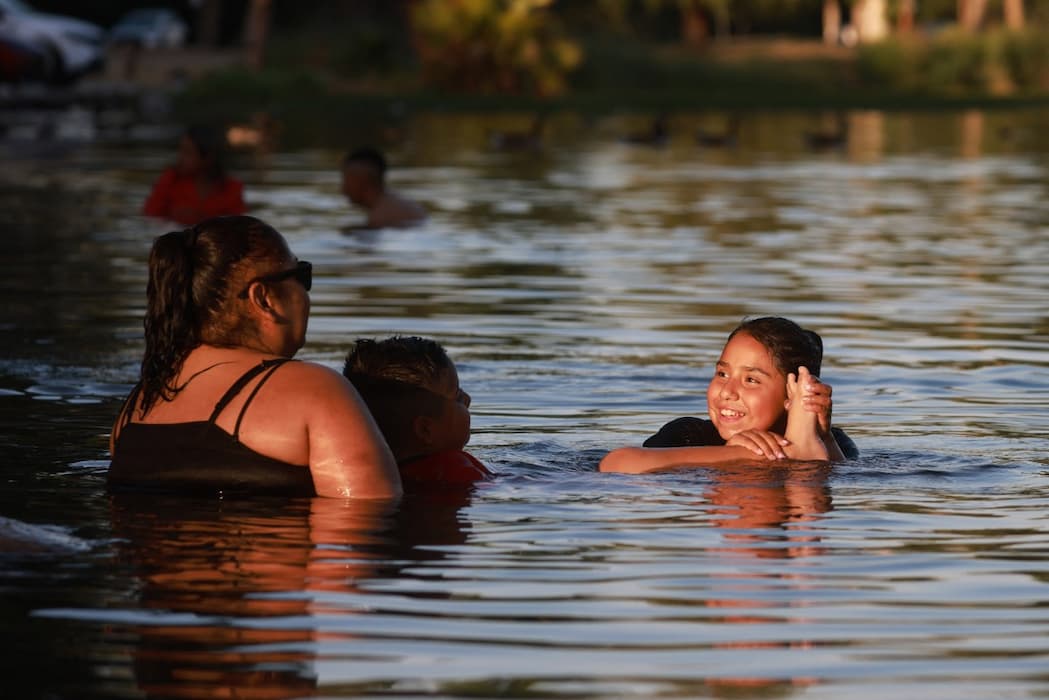 Onda de calor com temperatura recorde no Oeste dos EUA, família se refresca em lago na Califórnia