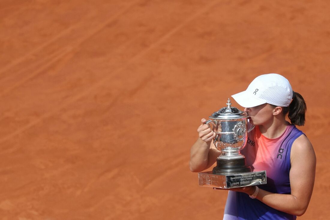 A polonesa Iga Swiatek beija o troféu ao comemorar após vencer a italiana Jasmine Paolini na final de Roland Garros